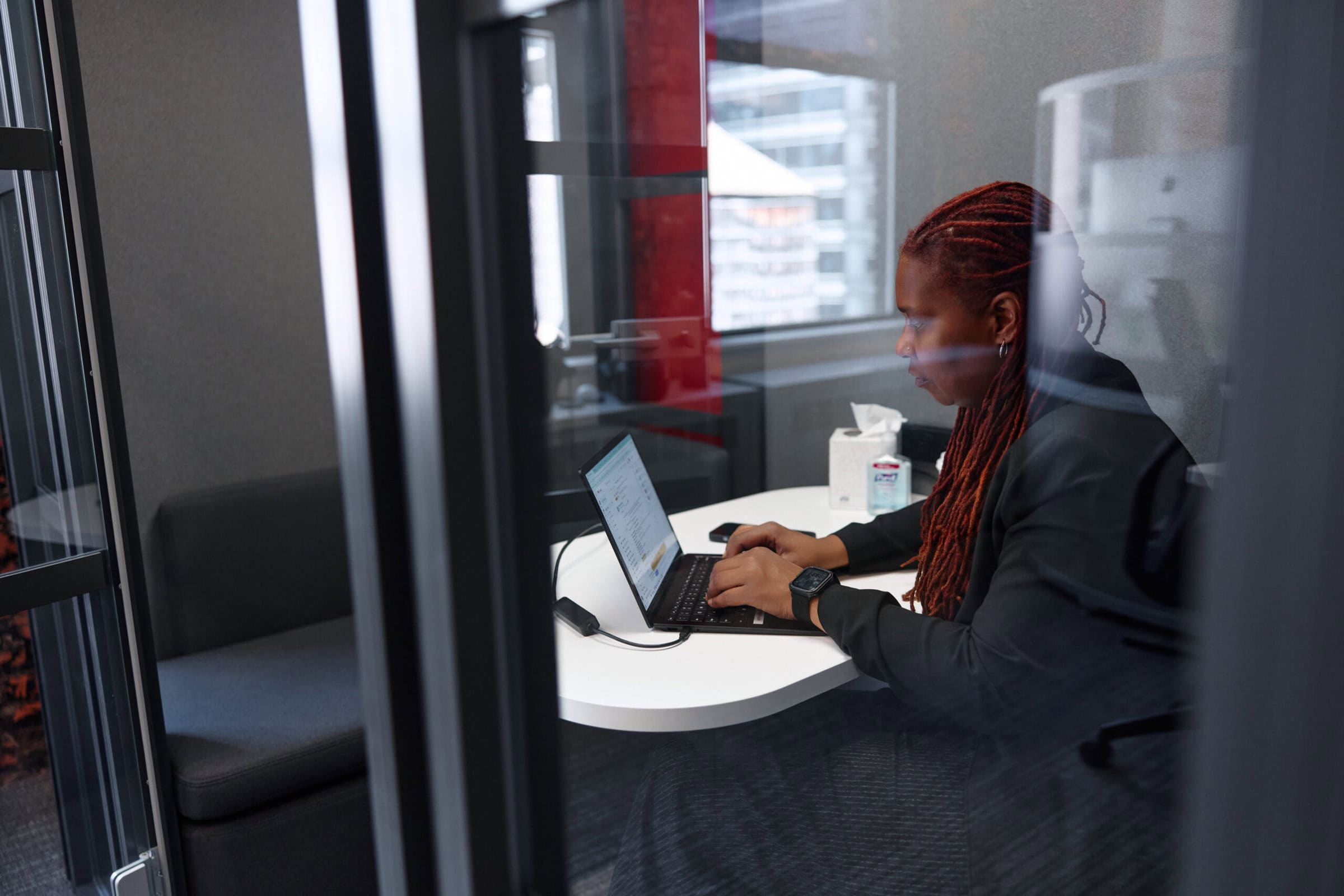 Close up of woman sitting in an office and working on a laptop